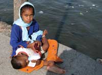 Street Life. Above, a young girl holds her infant brother while begging for money on a jetty leading out to the Haji Ali Mosque in Mumbai, India. Despite India’s booming economy, half of its population still survives on less than $2 a day.