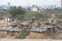Contrast. Brick shanties border the commercial skyline of Gurgaon, India.